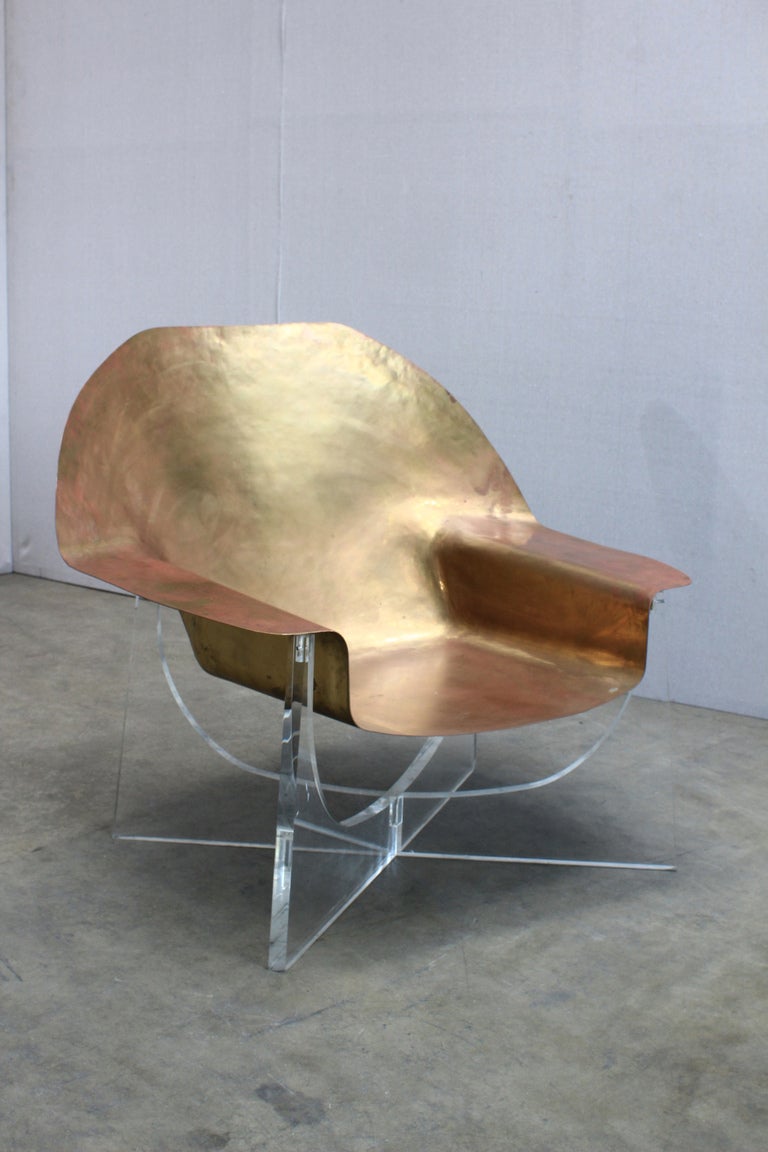 A Limited Edition Beaten Brass Chair by Philippe Hiquily. France, c. 1970. A gorgeous hand crafted low chair with a lucite base. This chair is the first in an edition of 40. Born in Paris in 1925, Hiquily debuted as a sculpter of metal at the age of