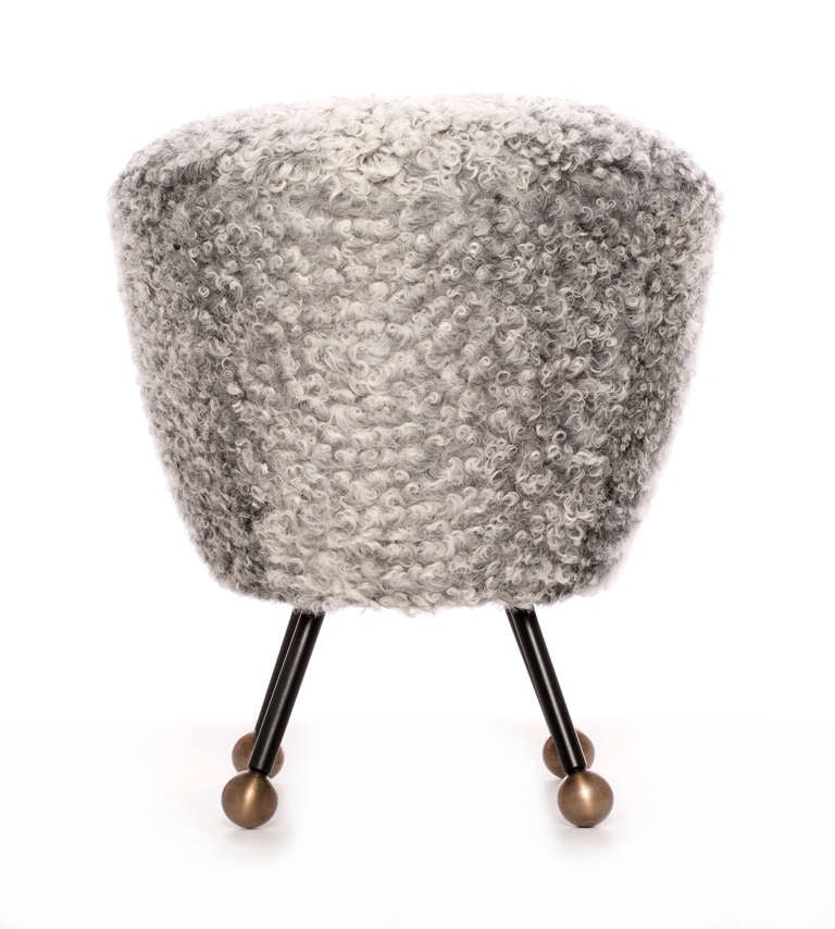 This confident ottoman with signature mixed metal detail was inspired by Post–War French furniture design and features Curly Tibetan Lambswool. The base is constructed of solid blackened bronze legs with burnished bronze ball feet. Handmade in Los