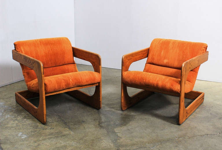 A Pair of Walnut Lounge Chairs by Lou Hodges. USA, 1970's. A gorgeous pair of cantilevered lounge chairs in solid walnut by Lou Hodges. A classic example of California studio furniture, upholstered in the original burnt orange velvet.