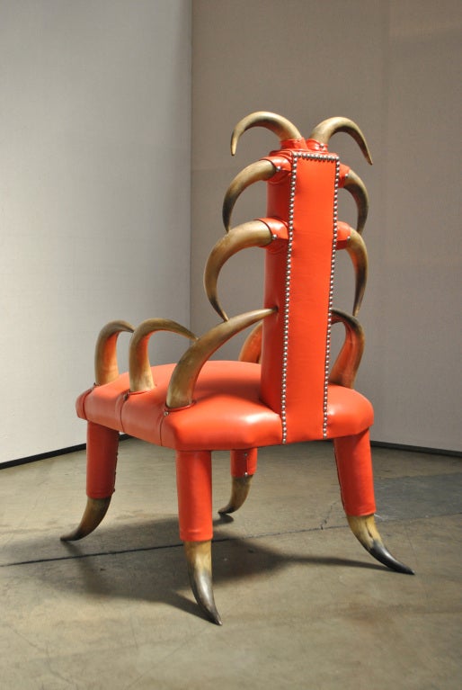A Steer Horn Club Chair. A unique and whimsical club chair crafted with real steer horn and deep orange leather.