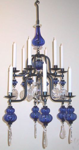 Beautiful Blue Glass 12-arm Wrought-Iron & Clear Glass Chandelier by Erik Hoglund. Very sought after for their very unique, unmatching and striking 
Design. The thick clear glass medallions each impressed with the image of a fish or a primitive