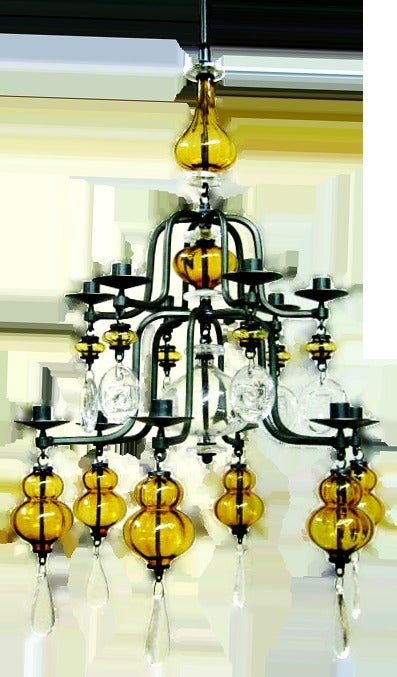 Beautiful Amber Glass 12-arm Wrought-Iron & Clear Glass Chandelier by Erik Hoglund. Very sought after for their very unique, unmatching and striking Design. The thick clear glass medallions each impressed with the image of a fish or a primitive