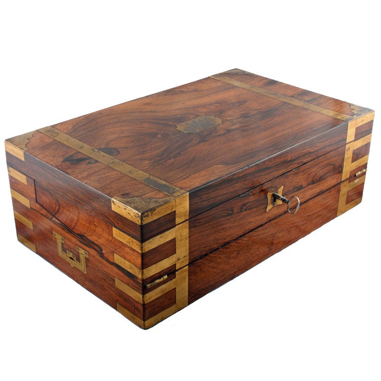 An early 19th century rosewood and brass bound double opening campaign box desk.

The box has military plate brass handles and the lid opens to a 1oo° - 110° degree angle and the box opens again to a writing slope. The two parts of the writing