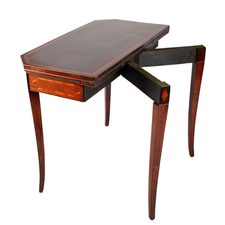 A fine Regency rosewood veneered turn over top card table.

The table stands on four tapering sabre legs with board satin wood banding around the top and a box wood edge.

The frieze has satinwood inlay and an ebony and box wood edge, the legs