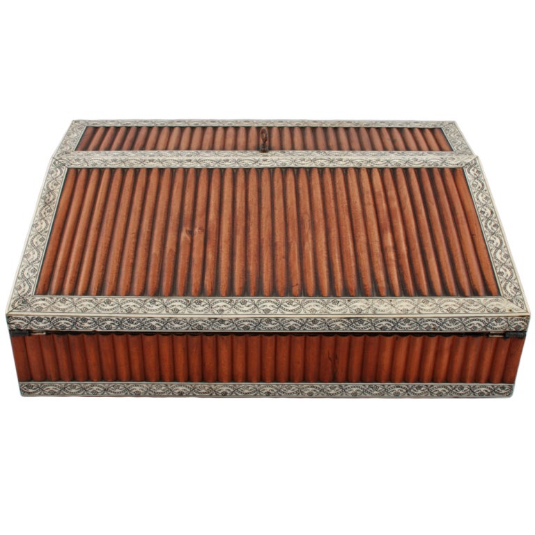 An early 19th century Indian Vizagapatam writing slope.

The box is made from sandal wood and is veneered with ivory that has been engraved and filled with lac, the ivory frames panels of sandal wood lats. The box when open has more Vizagapatam