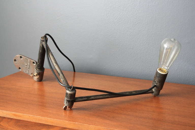 This is a vintage industrial wall mount steel task lamp. The wall bracket is stamped 