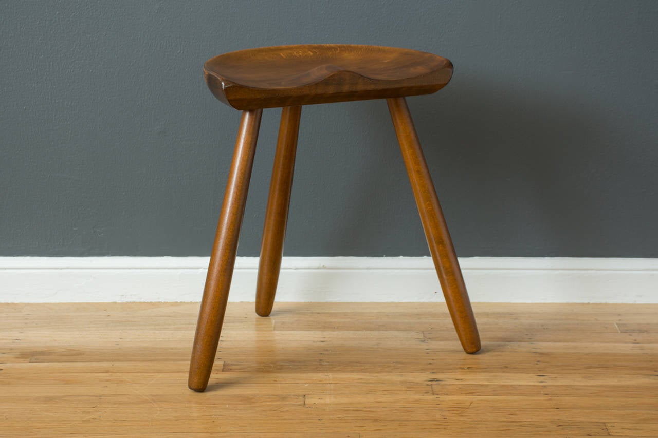 This is a vintage Mid-Century three-legged milking stool by Arne Hovmand-Olsen, made in Denmark. Stamp underneath the seat.