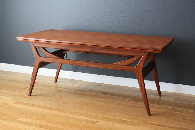 This vintage Mid-Century teak table can be extended and raised to use as a coffee table or as a dining table. The width increases to 40