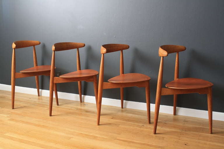 This is a set of four vintage Mid-Century stacking chairs designed by Hans J. Wegner for Fritz Hansen, Denmark, in the 1950's. They are solid oak with teak seats.