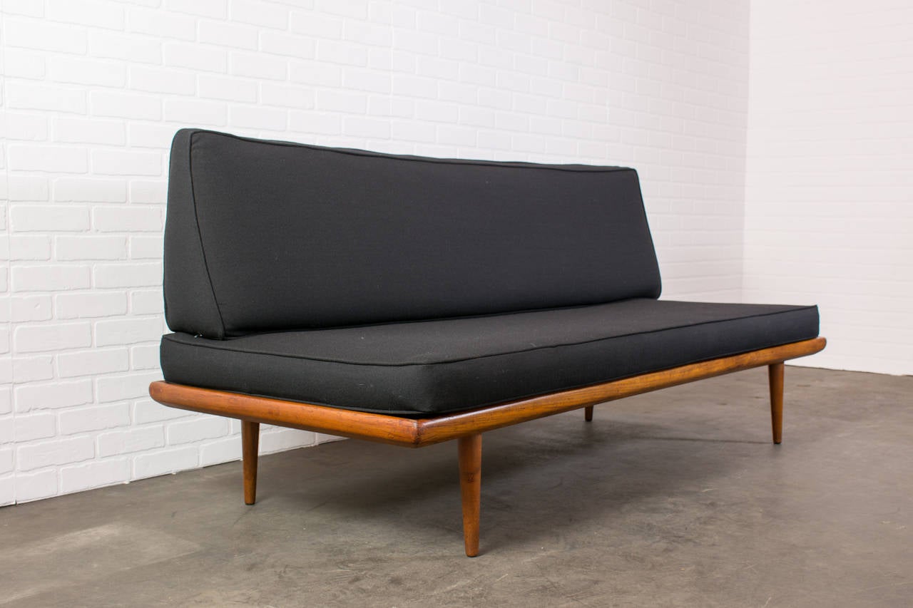 This is a vintage Mid-Century sofa/daybed designed by Peter Hvidt & Orla Molgaard for France & Daverkosen in the 1950's. It has a teak frame and the original black upholstery. The angled back cushion can be removed to be used as a daybed. Matching