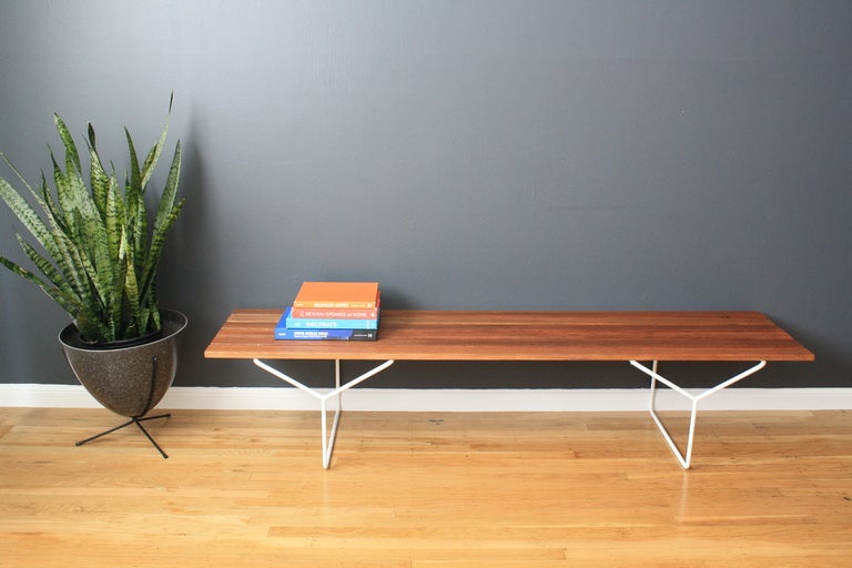 This Mid-Century Modern bench has a vintage metal base and what appears to be a new teak top. It is in great condition with age appropriate wear.