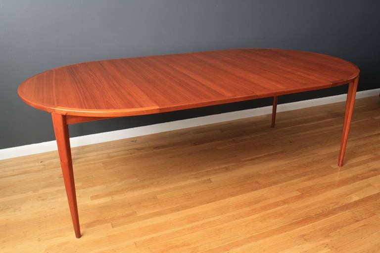 This is a Danish Modern teak dining table by Henry Rosengren Hansen for Brande Møbelindustri. The legs have a unique angled joint, and the profile of the leg is an interesting 