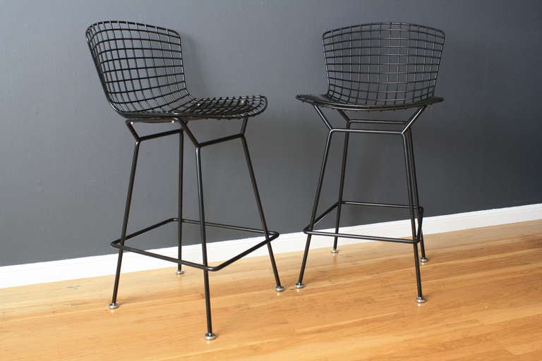 This is a pair of vintage Mid-Century black bar stools designed by Harry Bertoia for Knoll. They are in great original condition with the original Knoll seat cushions.