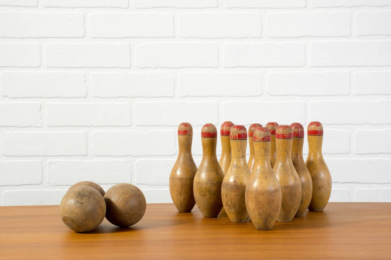 This is a set of ten vintage 20th century small wood bowling pins and three wood balls.

approximately 6.5