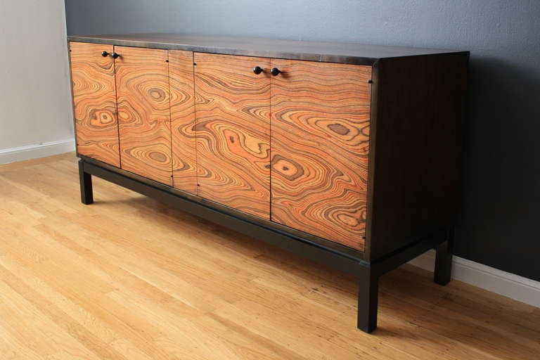 This sideboard/credenza has four zebra wood doors that open to reveal three drawers on one side and one adjustable shelf on the other side. The wood grain is unique. Great condition with vintage wear.