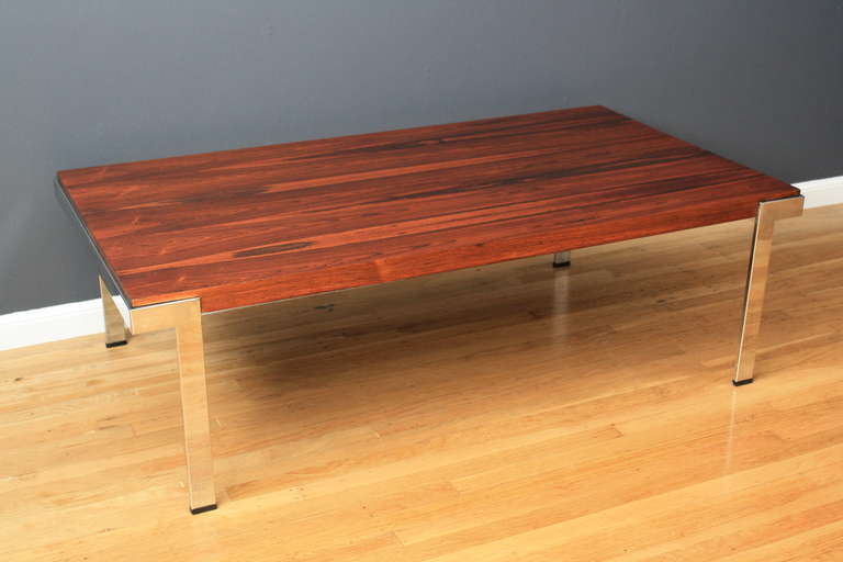 This is a vintage Mid-Century coffee table by Milo Baughman. It has a rosewood top and chrome plated steel legs.