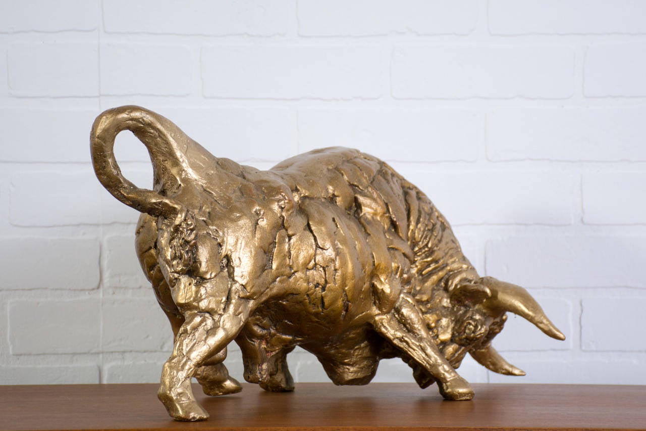 This is a vintage Mid-Century sculpture of a gold bull.