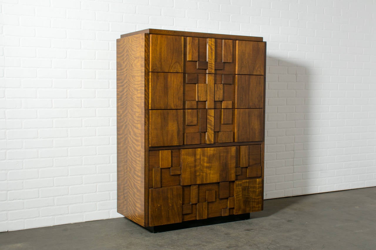 This is a vintage Mid-Century tall dresser by Lane. It has a walnut mosaic front and five drawers.