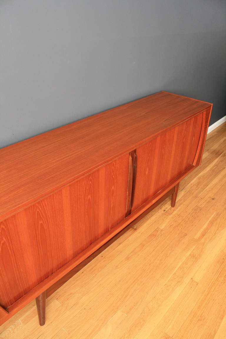This is a vintage Mid-Century sideboard with tambour doors that slide open to reveal 3 shelves (2 adjustable) and 7 drawers.