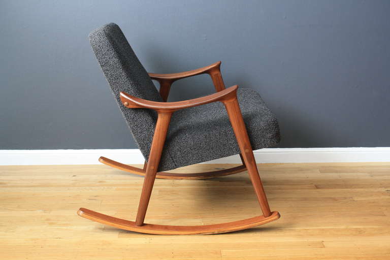 This is a vintage Mid-Century rocking chair that has been professionally reupholstered in a Danish grey wool.
