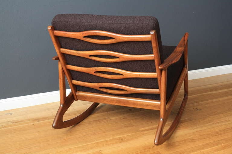 This vintage Mid-Century walnut rocker has been professionally upholstered in a dark Italian fabric and has new Pirelli straps. Great condition.
