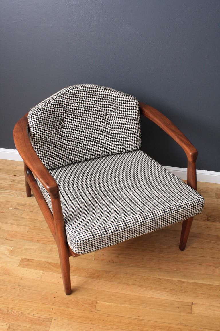 This vintage lounge chair was designed by Milo Baughman for Thayer Coggin. It has a walnut frame and professionaly upholstered cushions in a black & white houndstooth fabric.