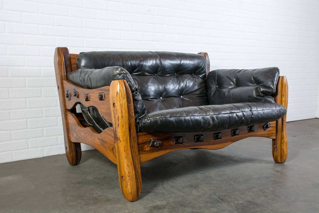 This rare vintage Mid-Century loveseat sofa was designed by Don Shoemaker in the 1960s as part of his descanso line. It features a cocobolo frame and the original black leather upholstery. Matching chair and ottoman also available.