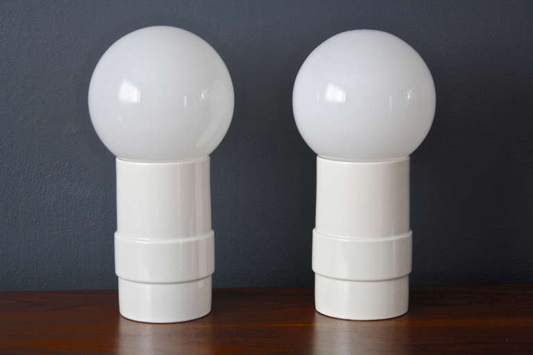 This is a pair of vintage Midcentury ceramic table lamps with glass globes that rest on top.  Switches are on the cords. The ceramic bases are 9