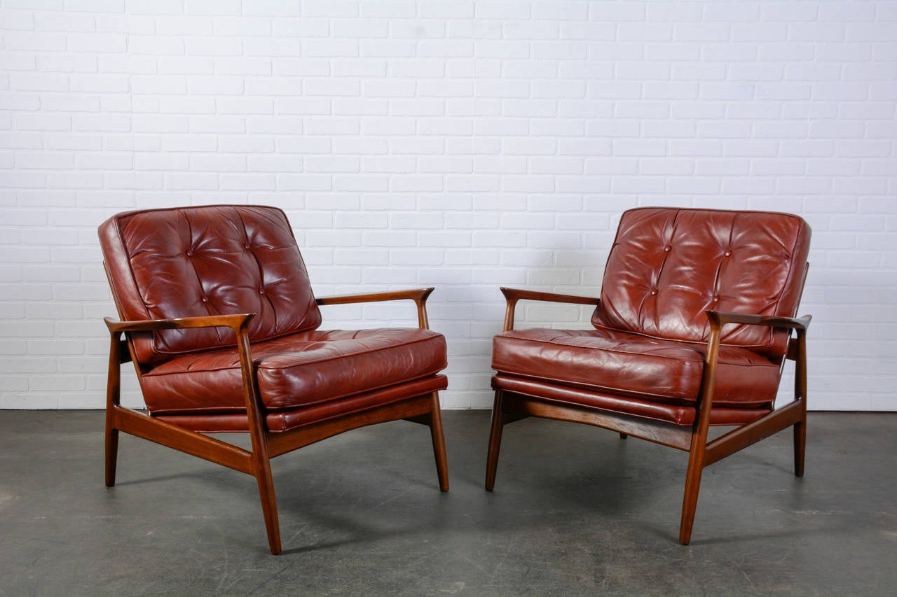 This is a pair of vintage Midcentury lounge chairs with the original leather upholstery.