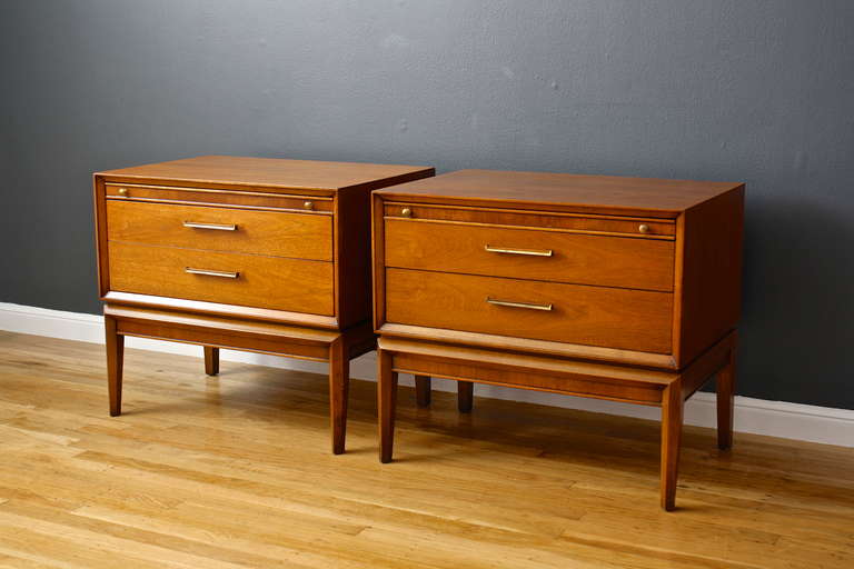 This is a pair of vintage Mid-Century walnut night stands.  They have two drawers each and a black laminate tray top that slides out from under the walnut top.
