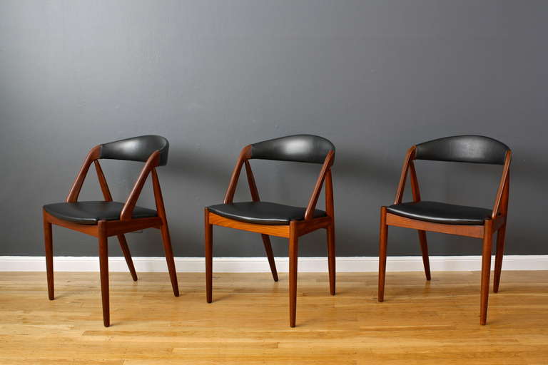 This is a set of six teak dining chairs designed by Kai Kristensen in 1956 (model #31).

These chairs are striking with their A-frame shape and curved backrests. Made in Denmark, but they are marked Raymor, which was the distributer in the USA.