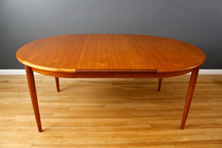 This is a vintage Mid-Century teak dining table with leaves designed by Kai Kristiansen and produced by Skovmand Andersen. It is 69.75