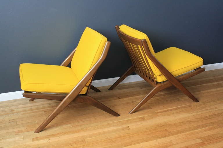 This is a pair of vintage Mid-Century walnut scissor lounge chairs designed by Folke Ohlsson for Dux. They have the original upholstery that is in great condition.