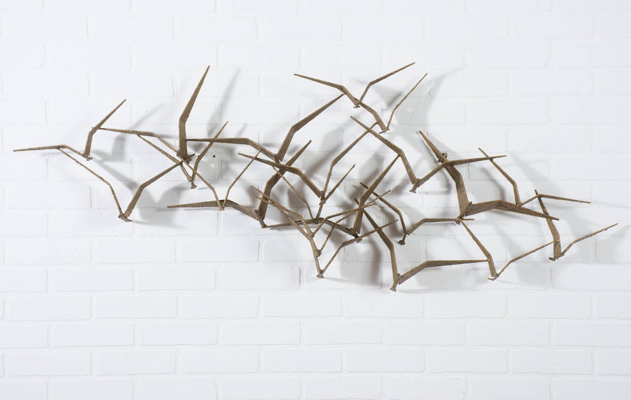 This Mid-Century Modern 'Birds in Flight' iron wall sculpture is signed C. Jeré. It has a gold brutalist finish.