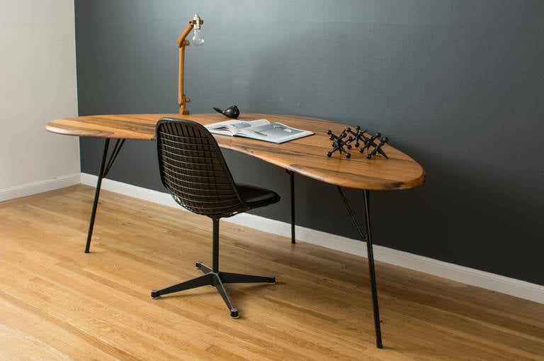This is a Mid-Century Modern boomerang shaped desk with a solid monkey wood top and iron hairpin legs.