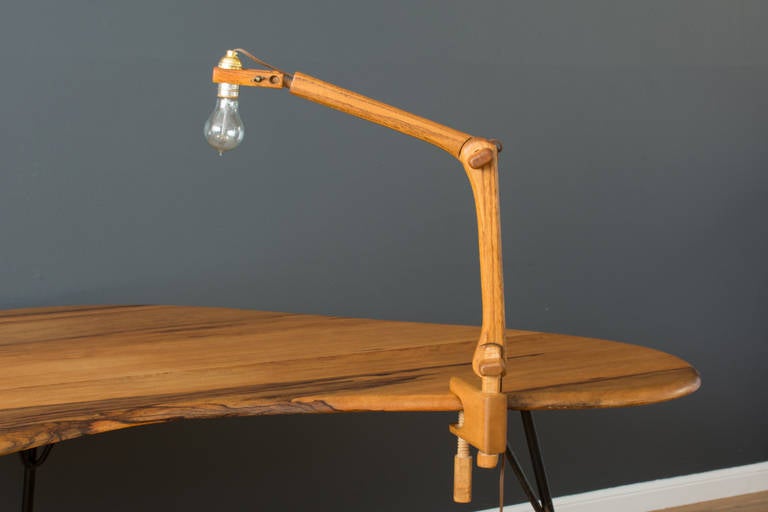 This is a vintage oak articulated desk lamp with wood clamp to attach it to a table top. The Edison bulb is included.