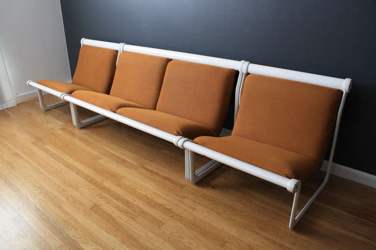 This is a Mid-Century Modern loveseat and pair of lounge chairs set that was designed by Morrison and Hannah for Knoll in the 1970's. They have the original orange upholstery and white aluminum frames. Th seat and back cushions hang like a sling in