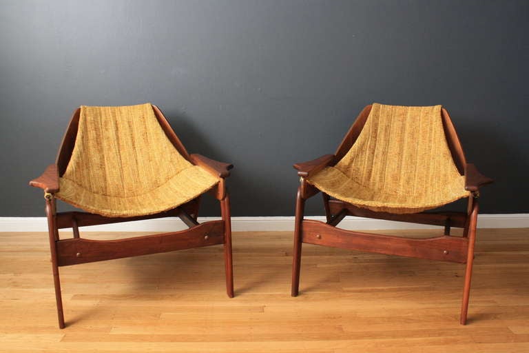 This is a pair of vintage sling lounge chairs designed by Jerry Johnson in 1964. They have a bent wood frame and the original sling seats.