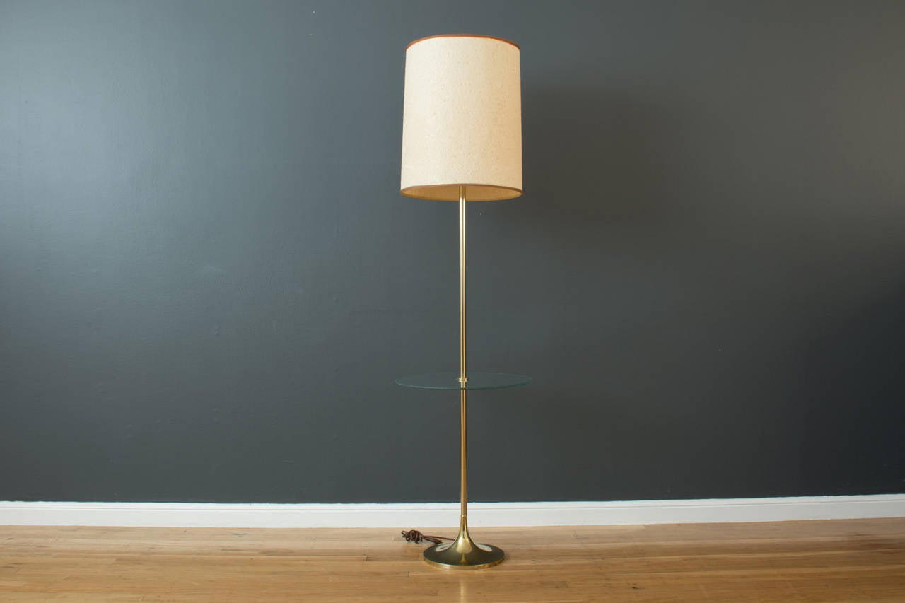 This is a vintage floor lamp with a gold tulip base and a round glass table by Laurel Lamp Mfg, 1960's.  Original shade.

60