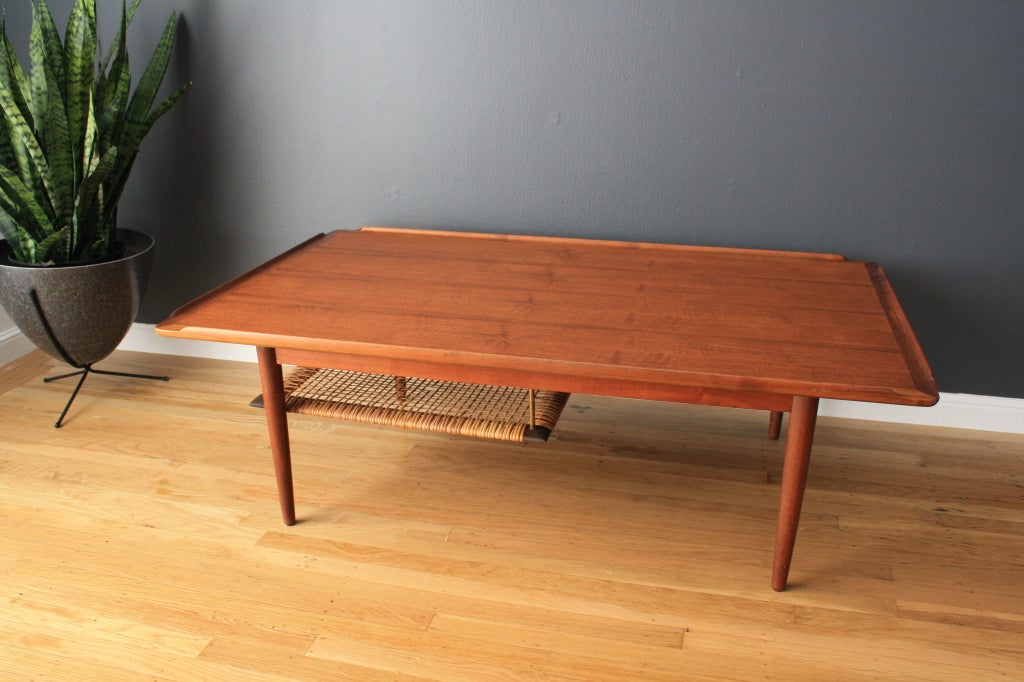 This vintage Mid-Century Selig coffee table has beautiful details such as raised lip edges and a suspended cane shelf.