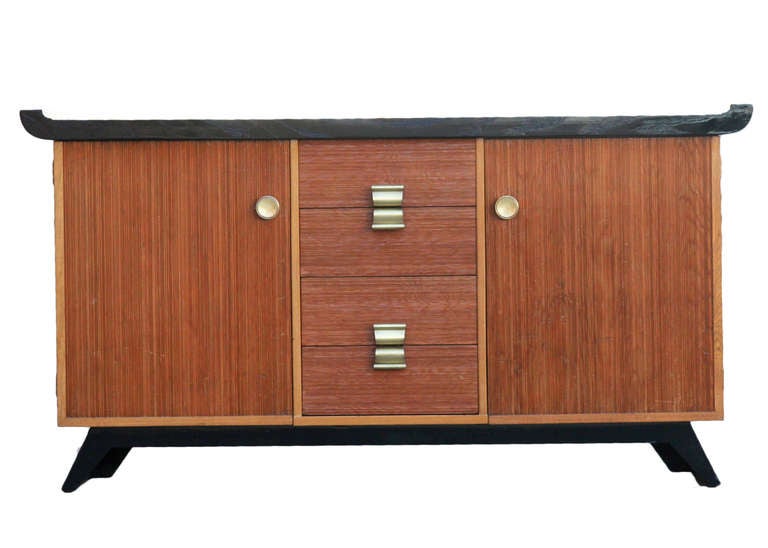 This Classic Paul Frankl buffet or credenza for Brown Saltman features the designer's trademark combed oak facade with mahogany construction and undulating pulls. The piece is composed of two doors flanking four central drawers. Stamped 