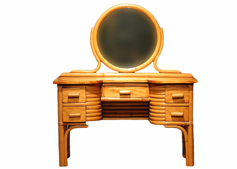 This Mid-Century Modern vanity in rattan and mahogany features an attached circular mirror, five drawers for plenty of storage and a matching chair.

This set was custom built for a little girl in 1934 who belong to a prominent West Los Angeles