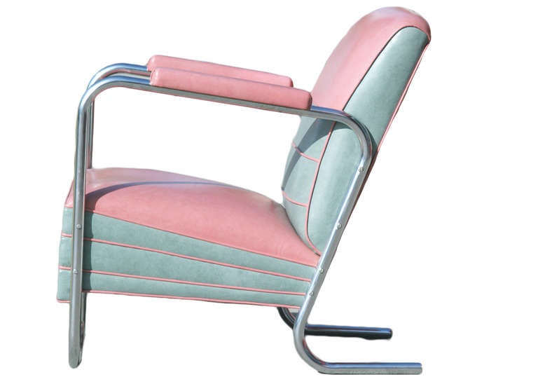 This Art Deco style jazz club chair in the manner of KEM Weber boasts dramatic pink vinyl upholstery with grey detailing and a chrome tubular frame.
