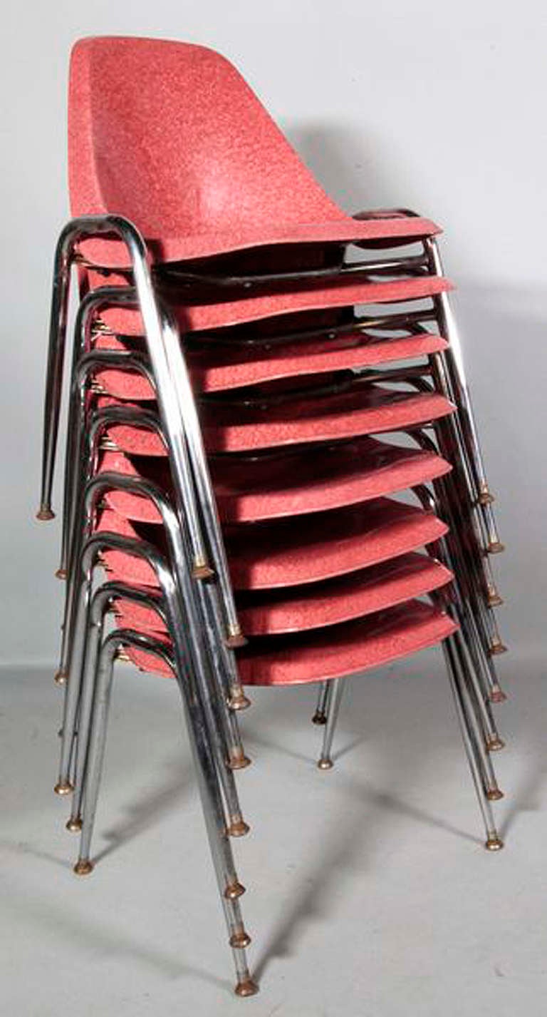 Set of eight red fiberglass bucket chairs with chrome legs in the manner of Knoll. These vintage chairs can be stacked as seen in photos. 

circa 1950, USA.

This set of chairs is located in Albany, New York and will be shipped from this