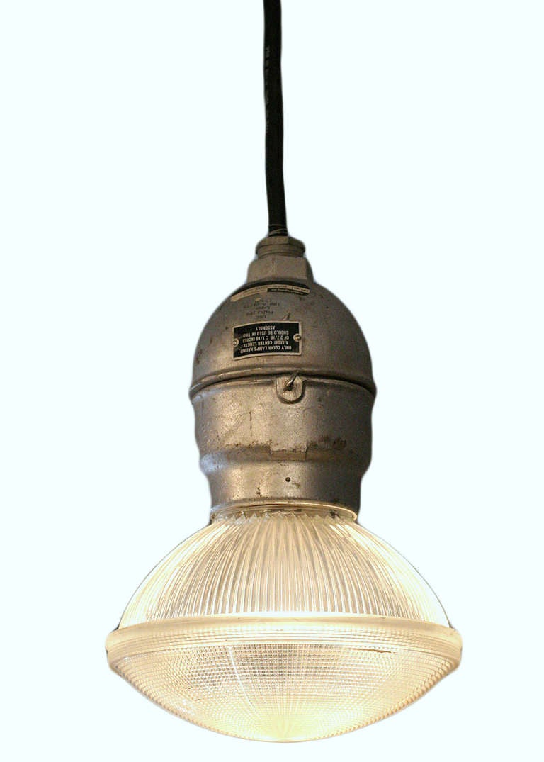 An industrial Holophane  Aluminum ceiling pendant with ribbed glass. (circa 1970). These fixtures are spark and vapor resistant, making them ideal for the kitchen. The pendants are slightly worn which compliments the exceptional patina of these