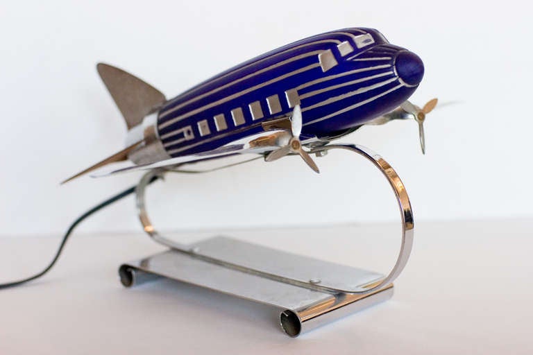 Streamline Chrome table lamp modeled after the famous Douglas DC-3 with hand painted windows and lines. The airplane features a cobalt glass body. The lamp was originally sold at the 1939 World's Fair and has been recently rewired.