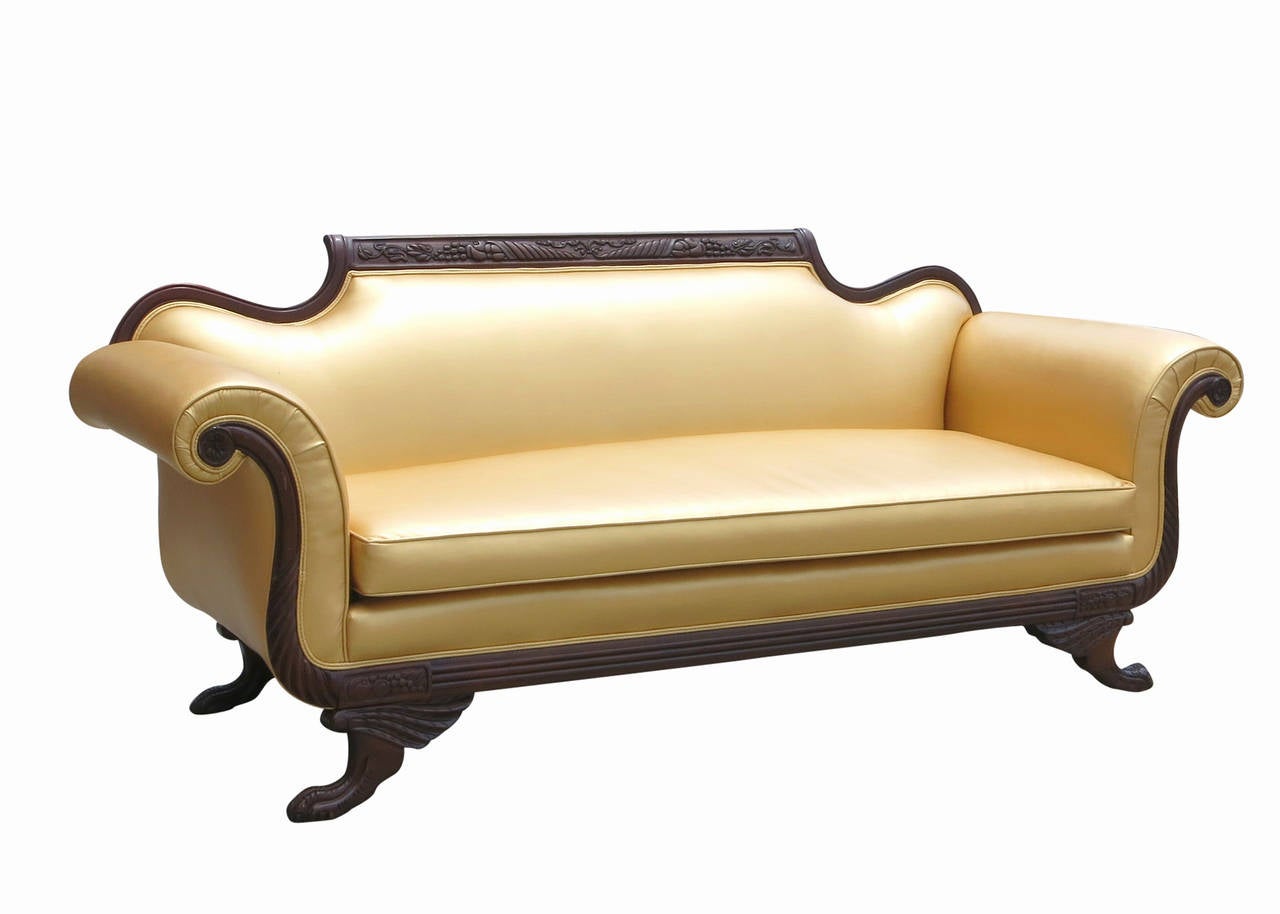 A high quality 1930's Neoclassical style sofa, this piece has a fluid design with fine hand-carved detail crafted out of a dark stained wood. The beautiful craftsmanship and color makes this sofa an easy fit in any room.