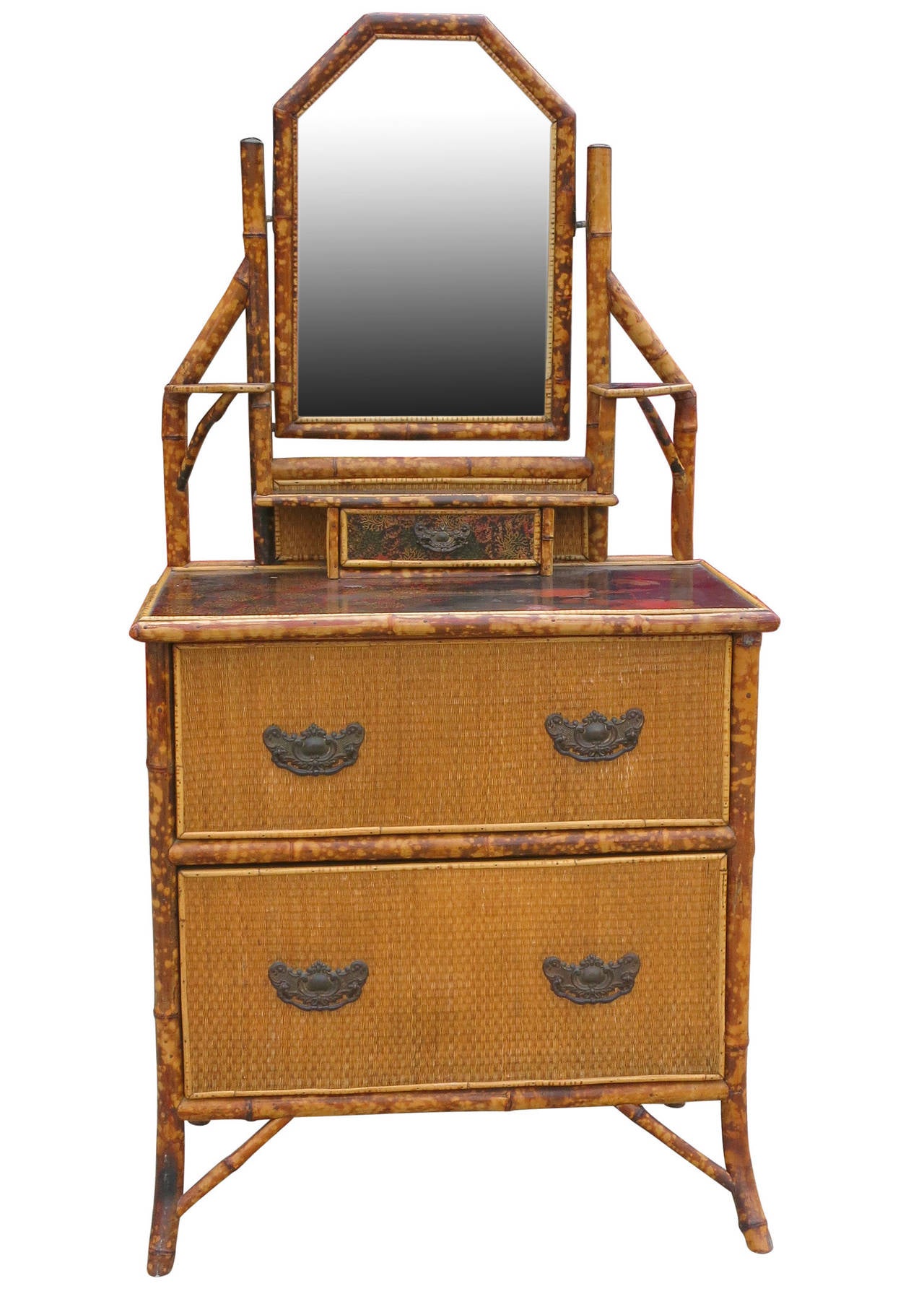 This late Victorian tortoiseshell bamboo chest has a black laquer top, grass-mat covered sides, and iron drawer pulls. The chest comes with a built-in vanity mirror complete with two small side shelves and small center drawer for jewelry.
