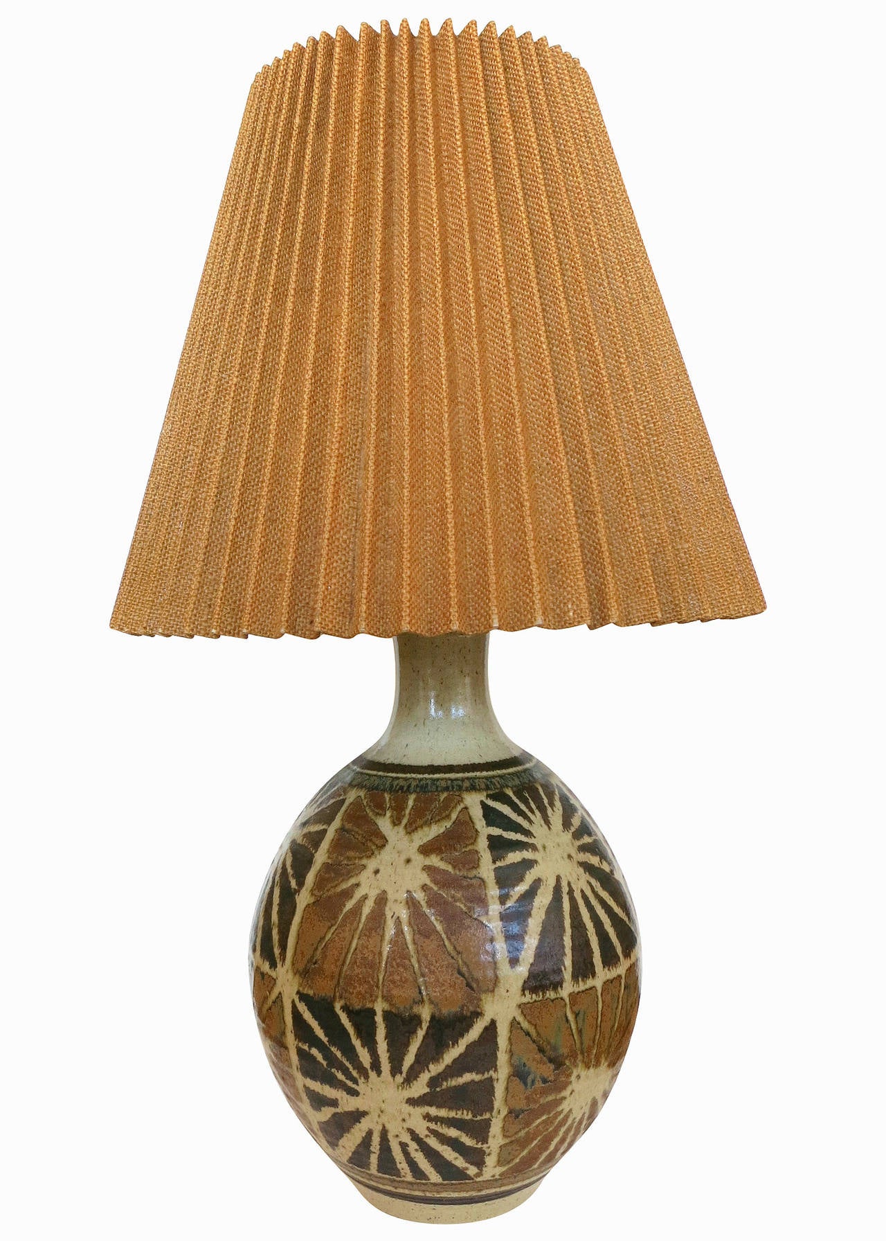 Circa 1950, this Modernist Starburst Art pottery lamp pair possesses a unique light brown starburst pattern that are accented with alternating shades of brown. The lamps were designed and made by San Diego based artist, Wishon-Harrell.

This set