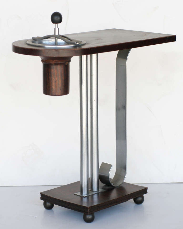 Art Deco Machine Age ashtray side table made of mahogany and polished chrome. Smokeless spinning ash tray is removable. The table was designed by Charles Hardy for Belmet Products of New York. Hardy was awarded Design Patent # 101,037 in 1936. 

A